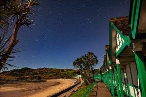 Dan Santilo glass placemat featuring Langland beach under a starry night sky.