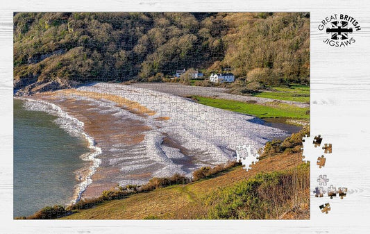 Completed Dan Santillo Pwll Du jigsaw puzzle showing a picturesque beach and hills.