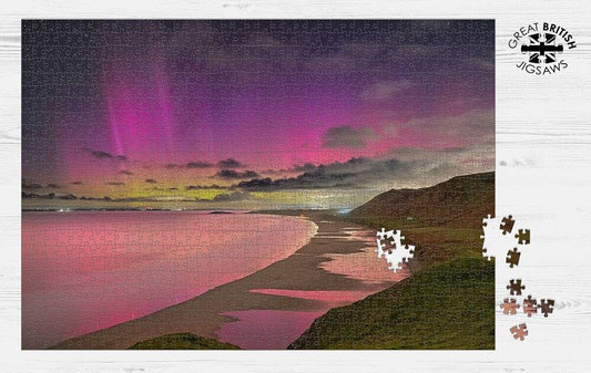 Completed Dan Santillo jigsaw puzzle of Rhossili lights with vibrant aurora.