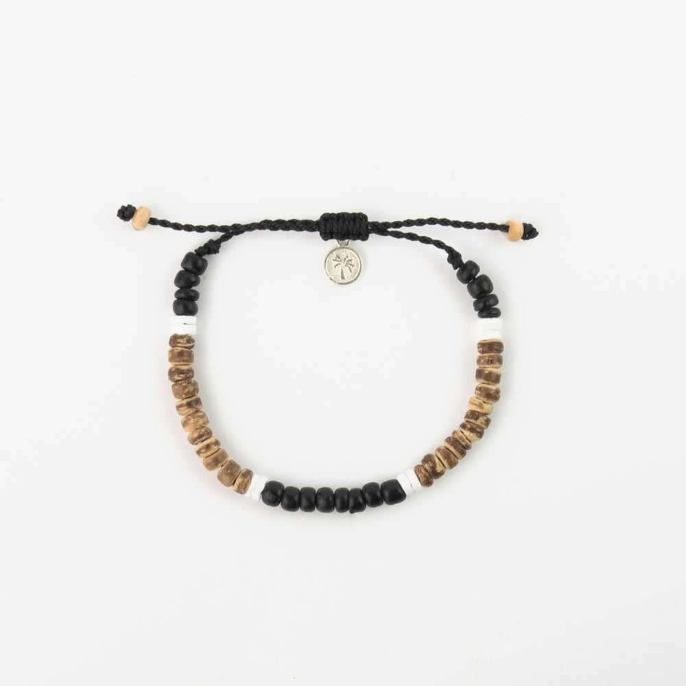 Sulawesi Sands bracelet with black, white, and brown beads and charm.