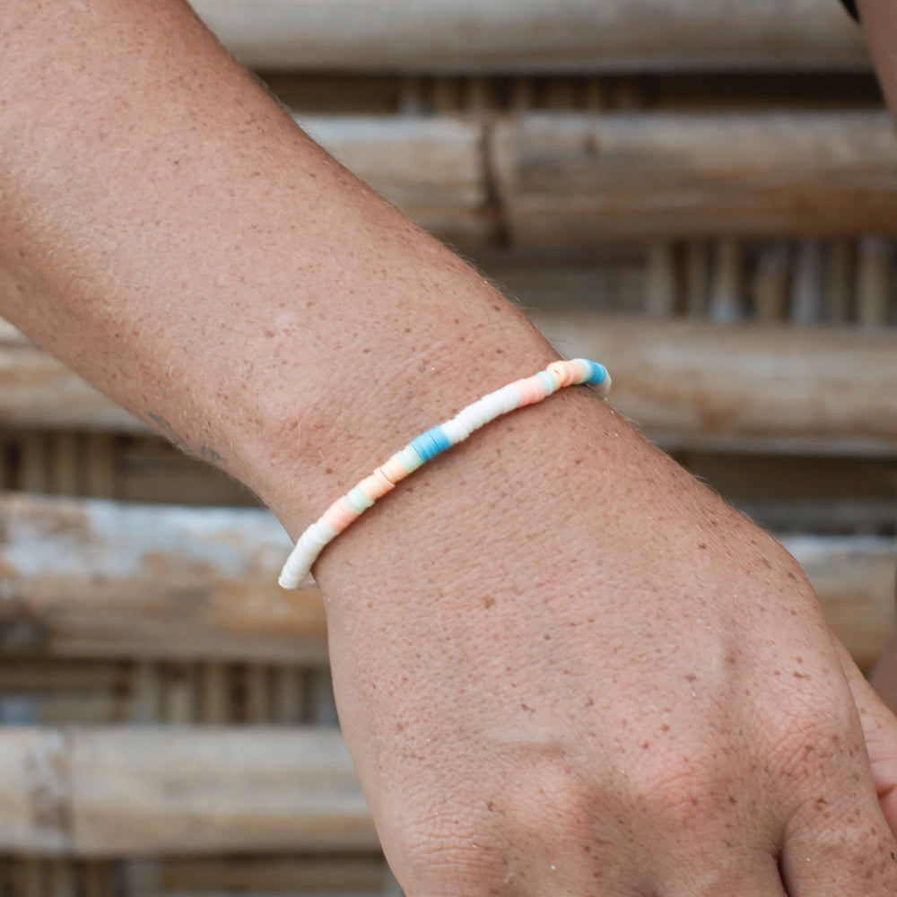 Hand wearing Pineapple Island Wategos clay beaded bracelet with pastel colors.
