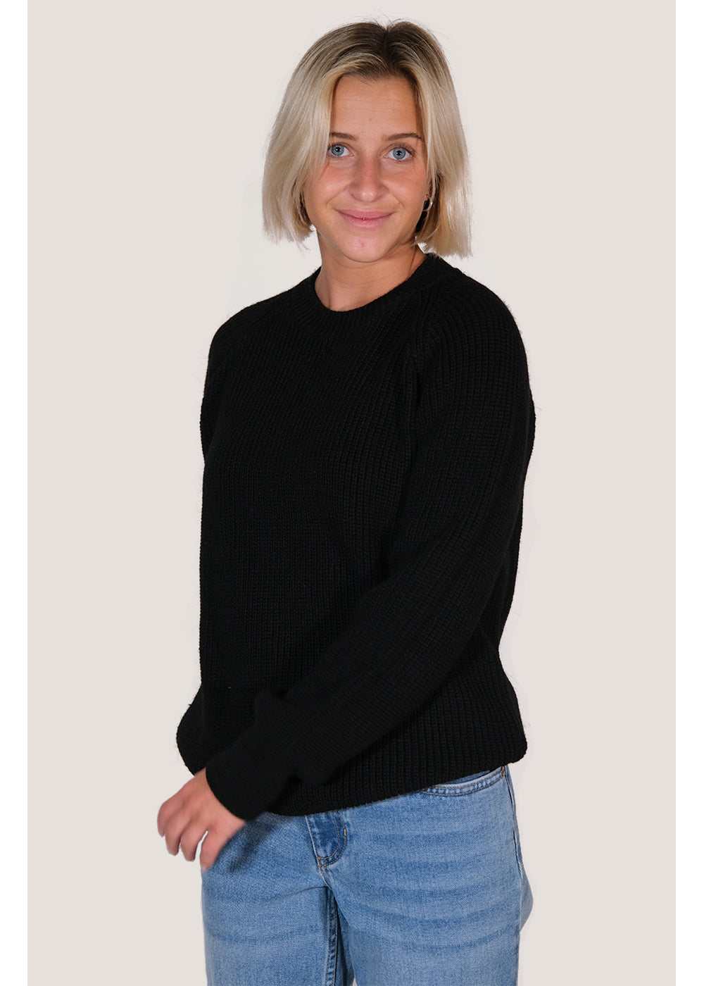 Sisstrevolution Barra Crew Sweater in black, worn by a model with jeans.