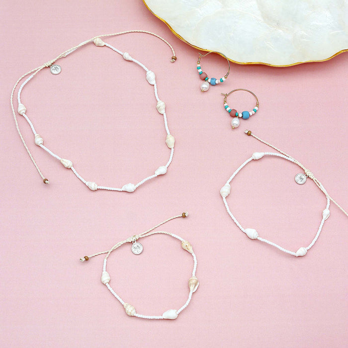 Flat lay of GIADA PECAHAN WIRE HOOP EARRINGS with matching shell bracelets on pink background, ideal for gifting or summer accessories.
