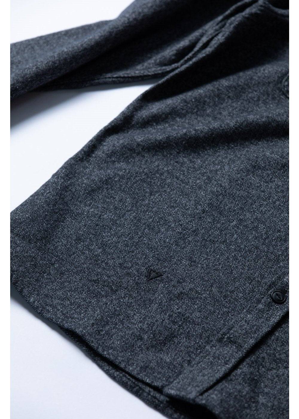 Close-up of Vissla Shaper Eco Flannel fabric and hem details in black.