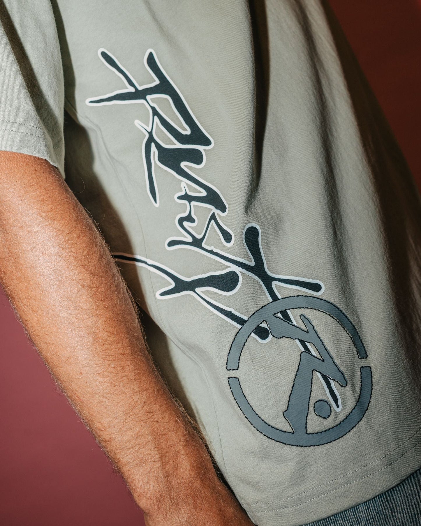 Close-up of logo on back of beige men's t-shirt, short sleeve