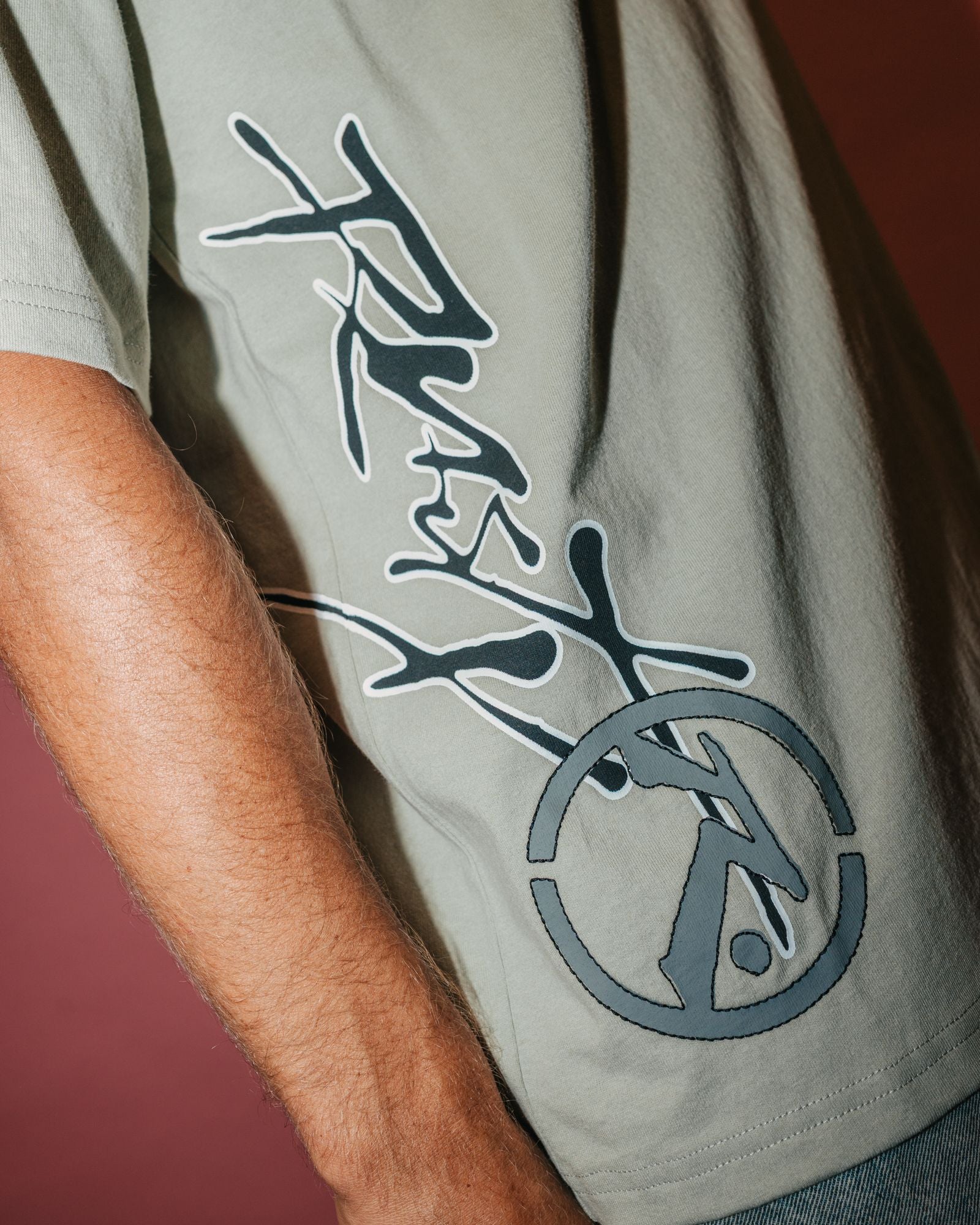 Close-up of logo on back of beige men's t-shirt, short sleeve