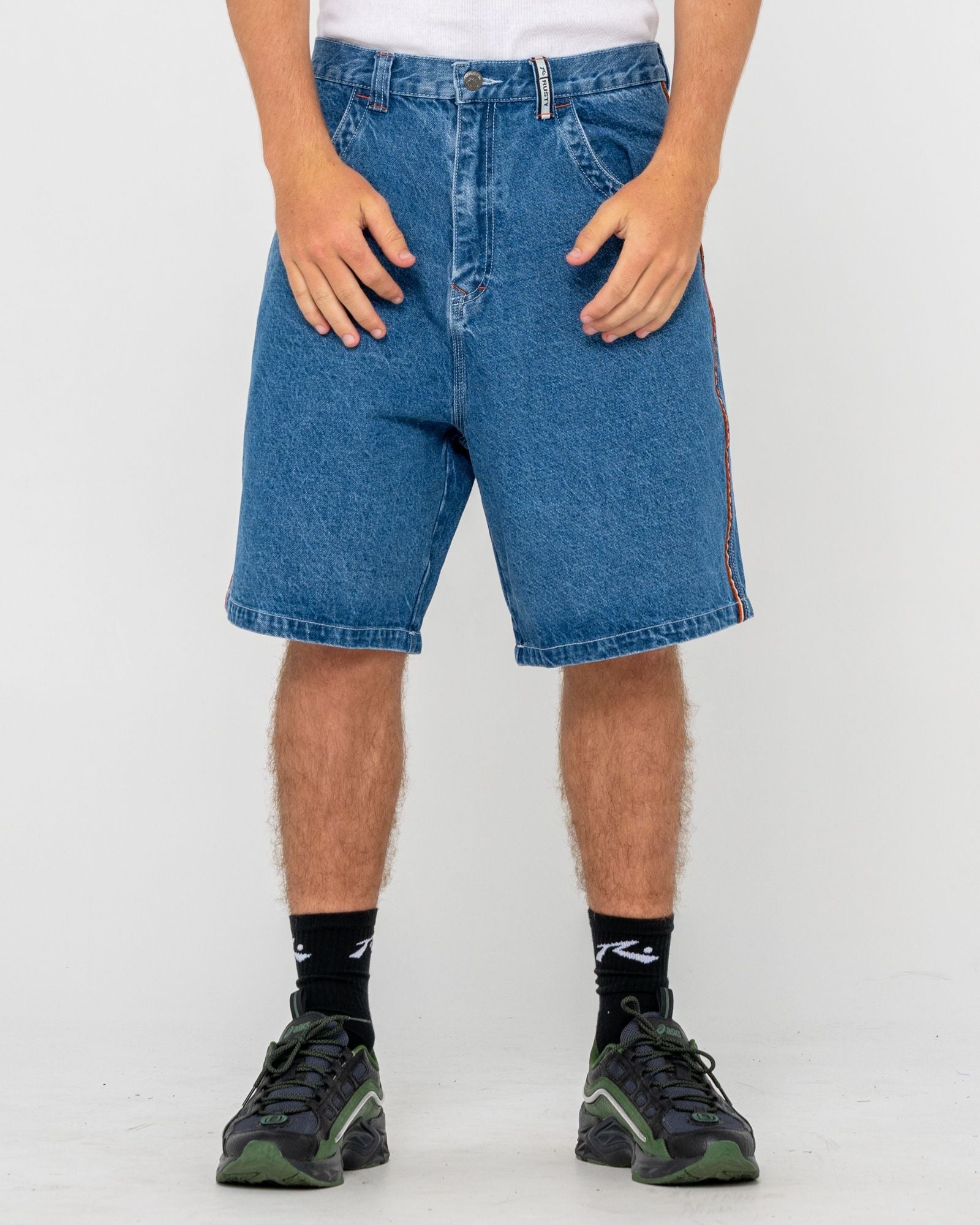 Close-up of men's denim shorts with orange embroidered logo