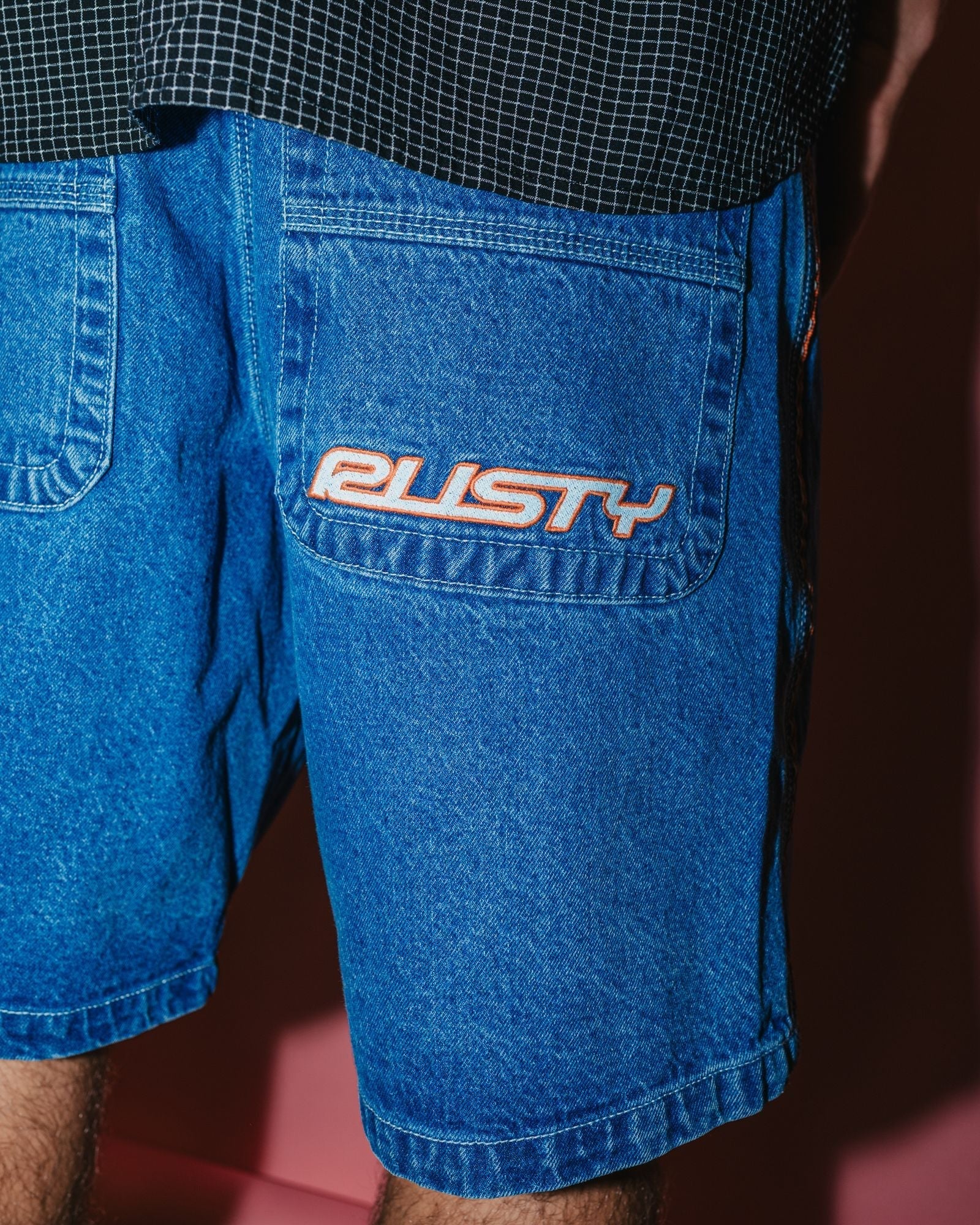 Men's denim shorts with orange logo embroidery on back pocket