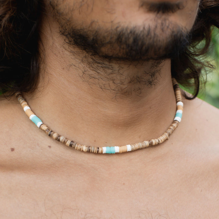 Nomad disc necklace with earthy tones and turquoise accents worn by a model.