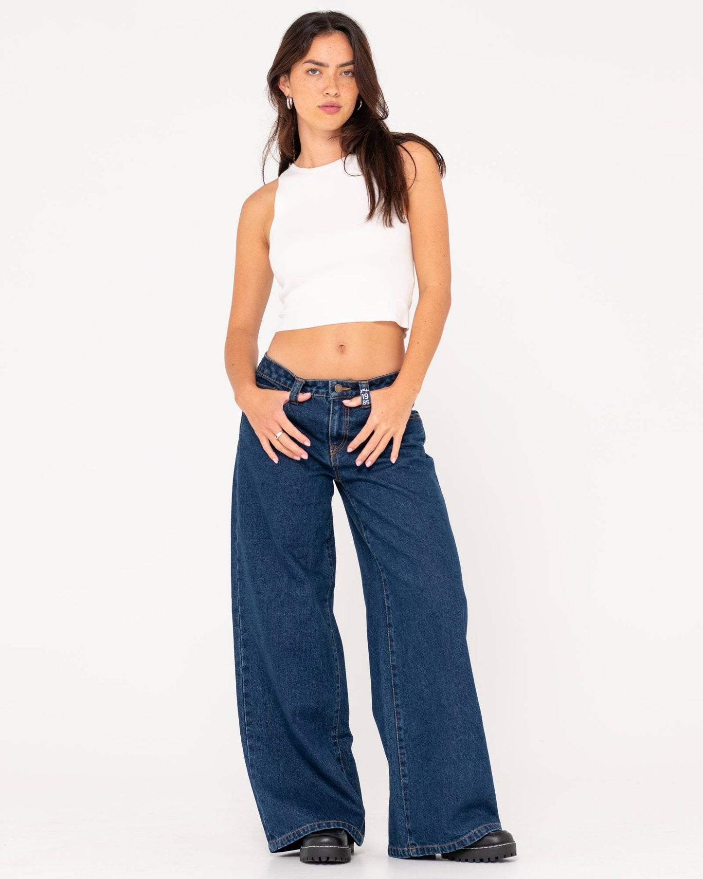 Model wearing Rusty Low Rise Super Wide Leg Jean styled with a white crop top.