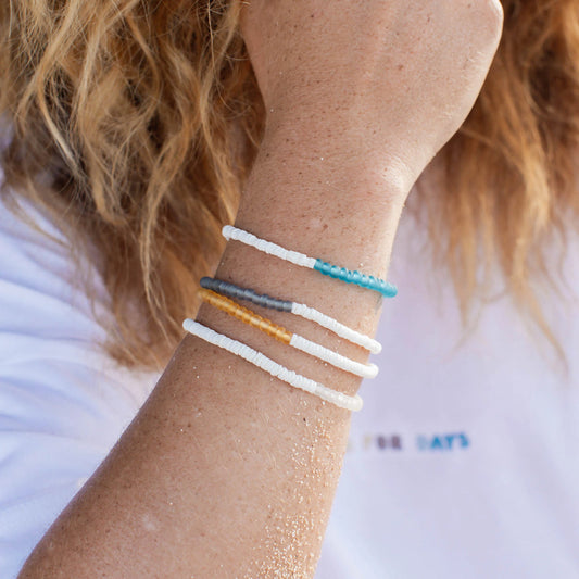 Woman wearing Pineapple Island Savu Puka Shell & Frosted Glass Bracelet in white.