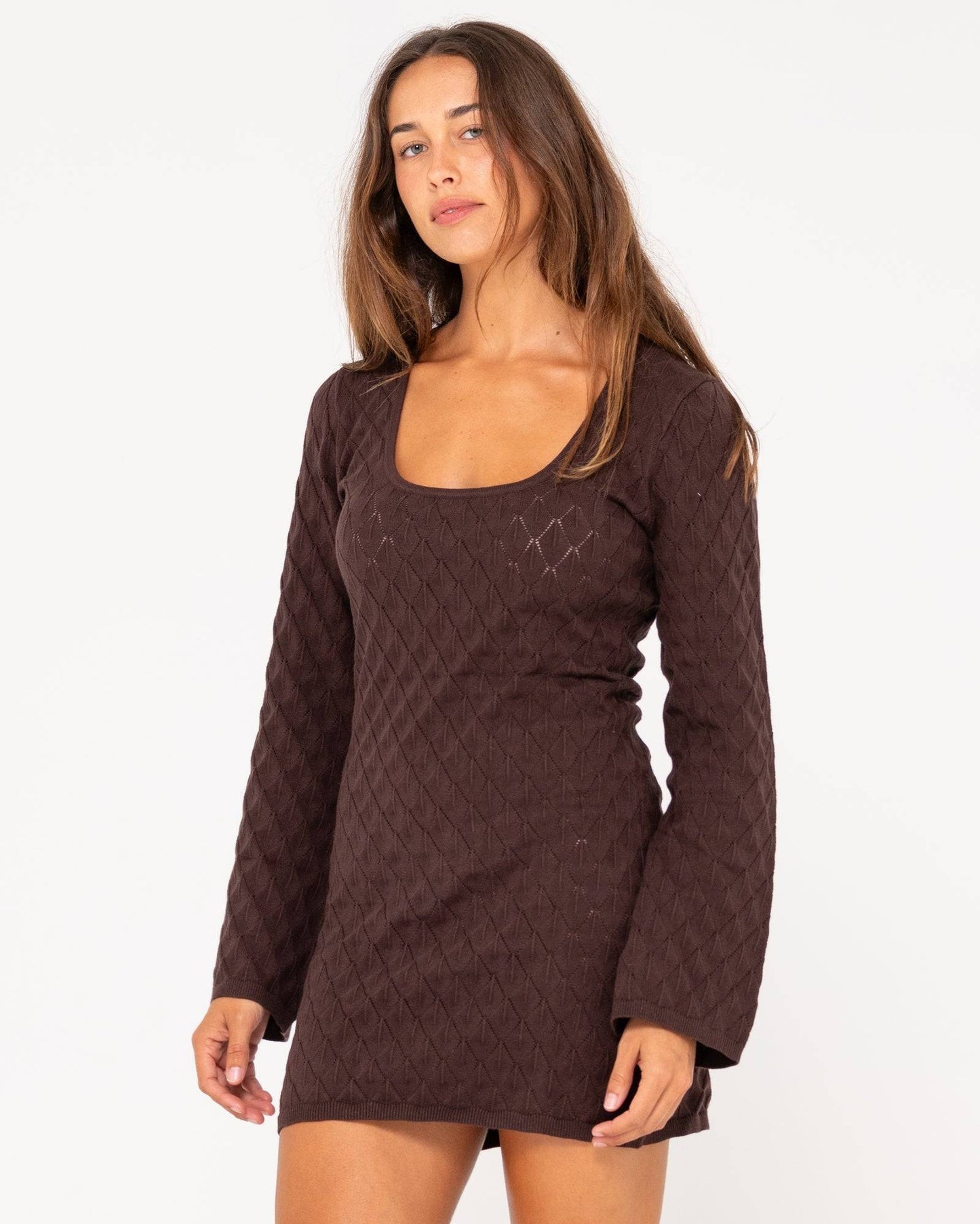 Side angle of Rusty Leo long sleeve knit mini dress in brown with a fitted silhouette.
