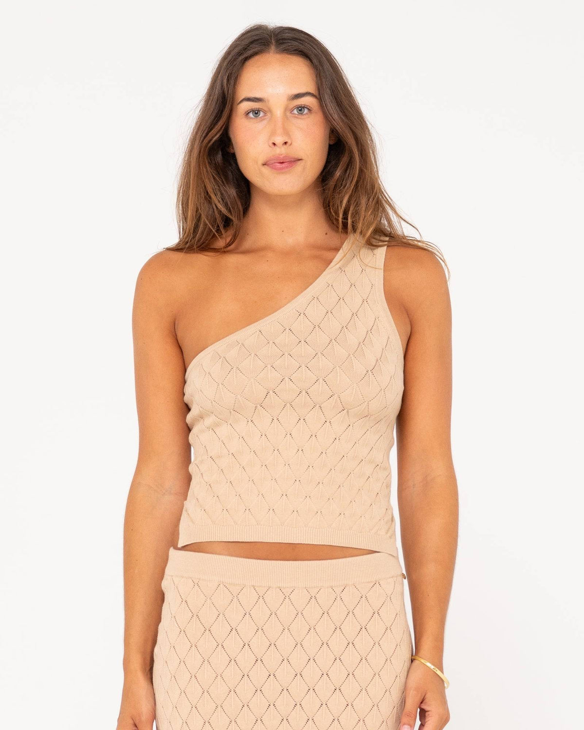 Rusty Leo one shoulder top in beige with textured diamond pattern.