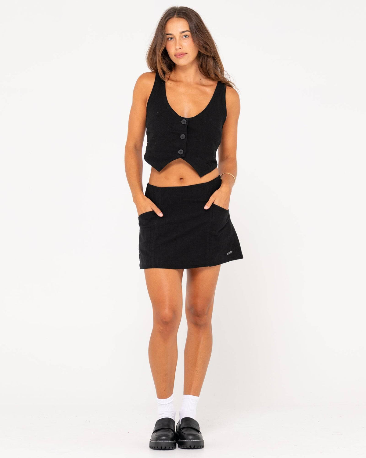 Model wearing Rusty Sicily Mid Rise Mini Skirt with matching black top.