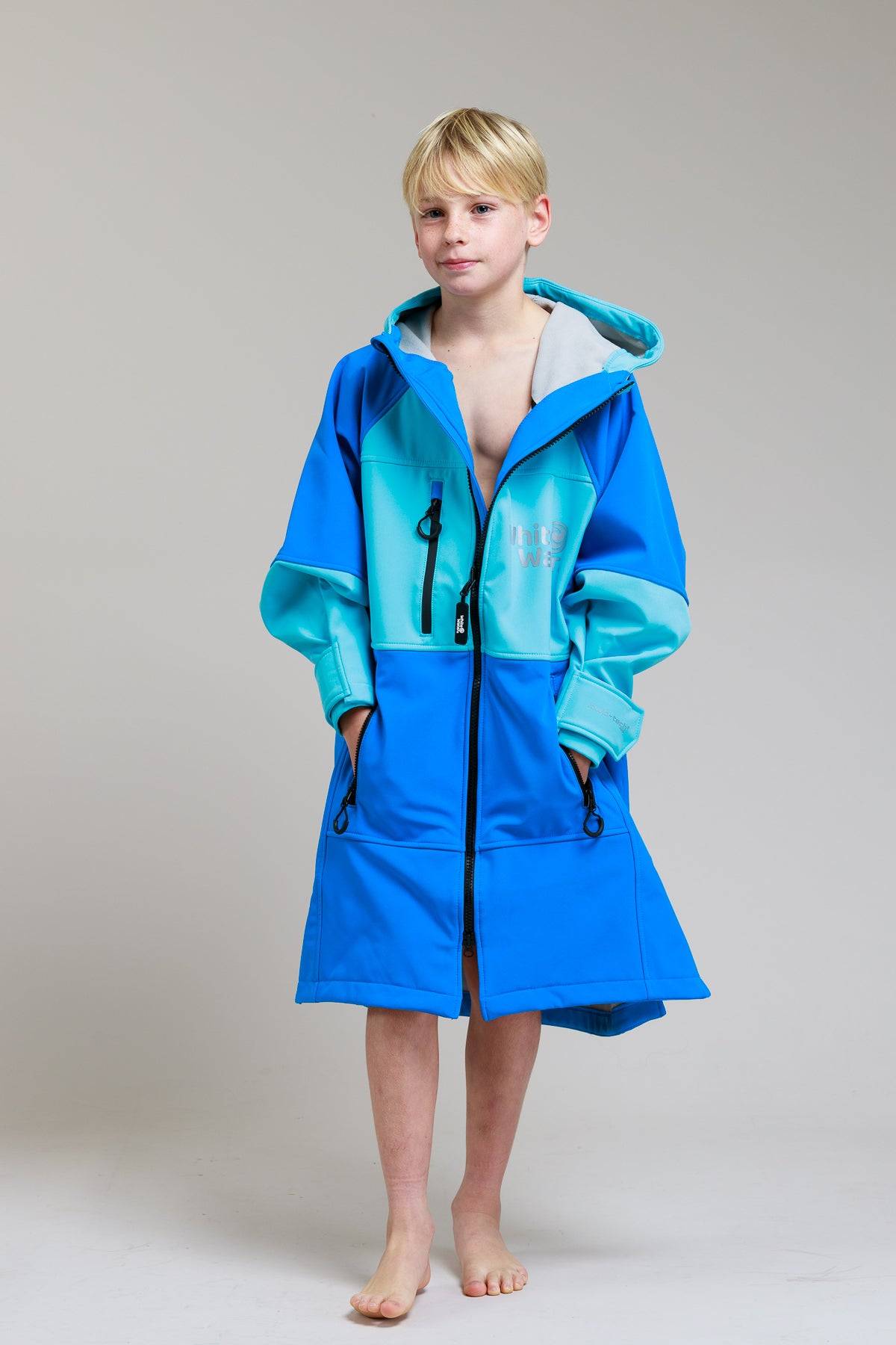 White Water Kids Soft Shell Robe in cobalt blue, front view with hands in pockets.