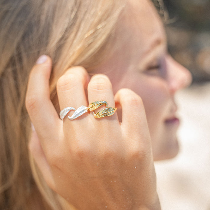 Gold Pineapple Island Bocca Feather Ring styled on a hand, paired with a silver ring for a chic look.