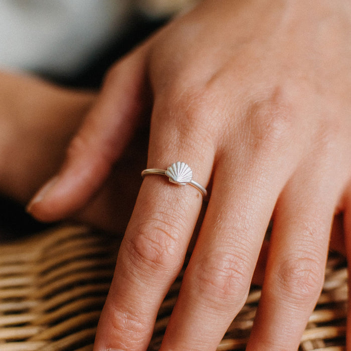 Silver adjustable shell ring on hand, showcasing elegant beach-inspired design.