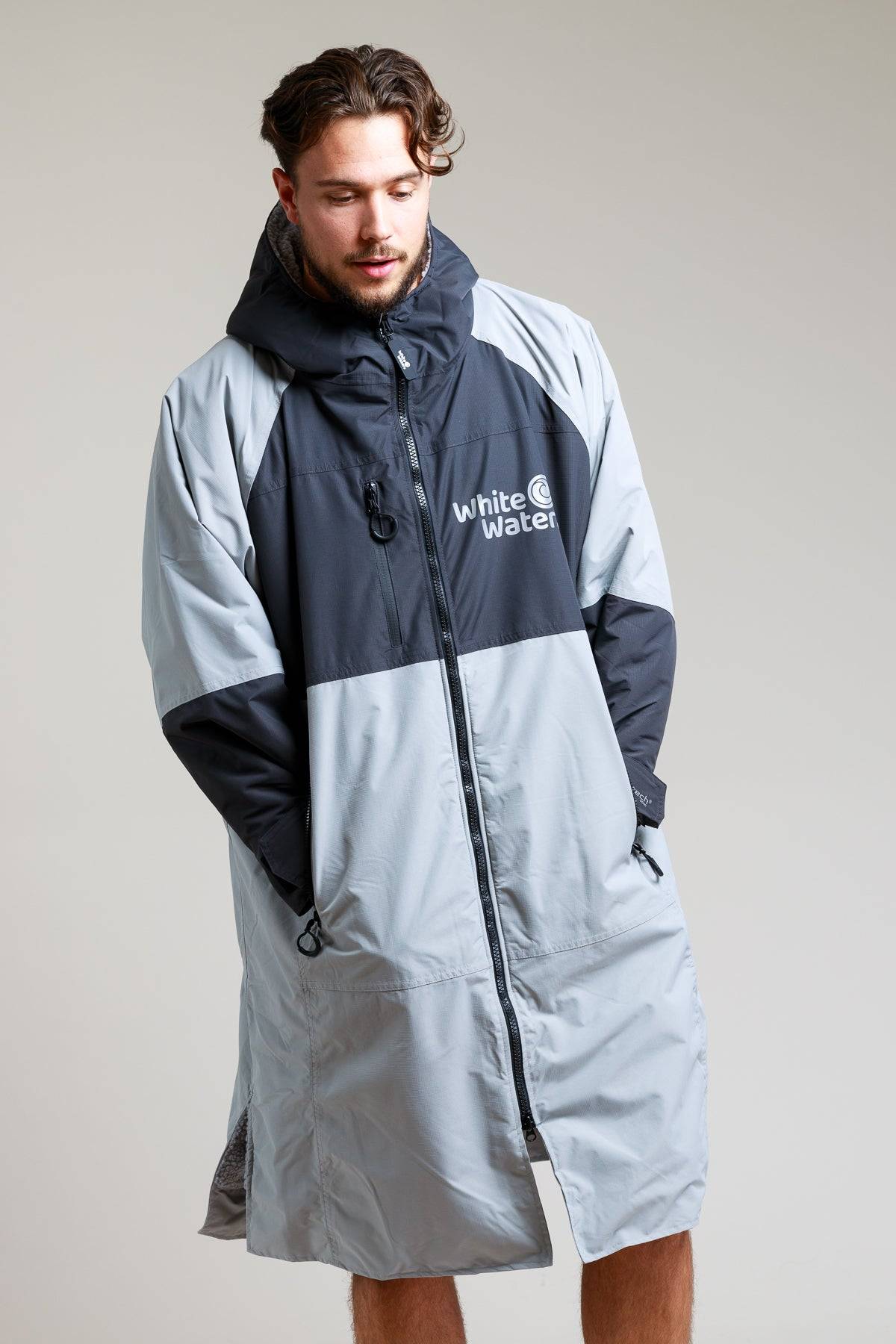 White Water Adult Hard Shell Robe in grey, front view with hood, modeled by a man.