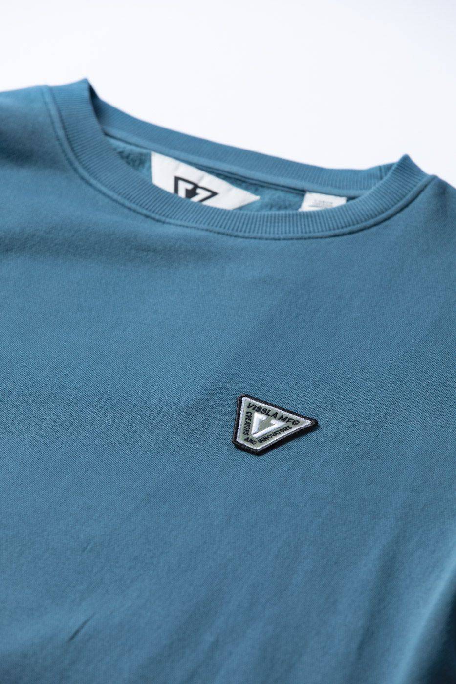 Close-up of Vissla Solid Sets Eco Crew sweatshirt logo detail.